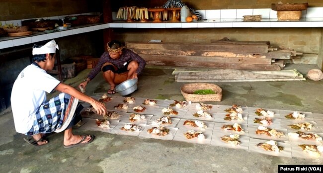 Warga Desa Adat Penglipuran sedang mempersiapkan hidangan untuk selamatan usai menggali sumur. (Foto: VOA/ Petrus Riski)