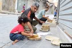 FILE - Residents spread bread for cooling in Old Aleppo, Syria.