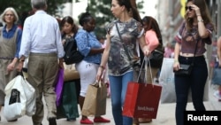 FILE - Shoppers carry bags in London, Aug. 25, 2016. The falling value of the British pound vs. other currencies is making London more attractive to bargain-hunters.