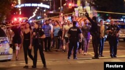 People leave an area cordoned off by police near the scene of a shooting incident in Toronto, Canada, July 22, 2018.