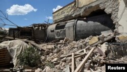 A train carriage is seen after crashing into a house following a derailment, in the town of Adendro in northern Greece, May 14, 2017. 