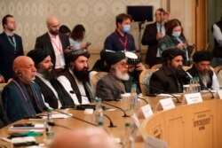 Rais wa zamani wa Afghanistan Hamid Karzai (kushoto) na Muasisi mwenza wa Taliban Mullah Abdul Ghani Baradar (2R) wakihudhuria mkutano wa kimataifa juu ya Afghanistan kutafuta suluhisho la amani kutatua mgogoro wa Afghanistan huko Moscow Machi 18, 2021. (Photo by Alexander...