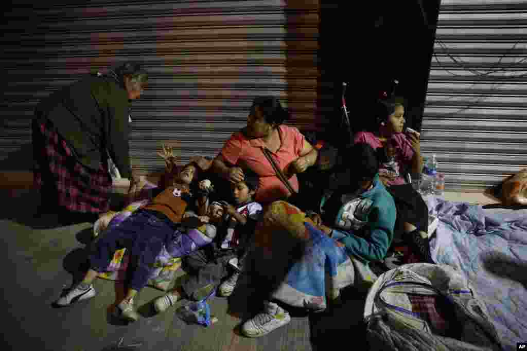 Families fearing aftershocks prepare to sleep on the street in the Roma neighborhood of Mexico City, Sept. 19, 2017.