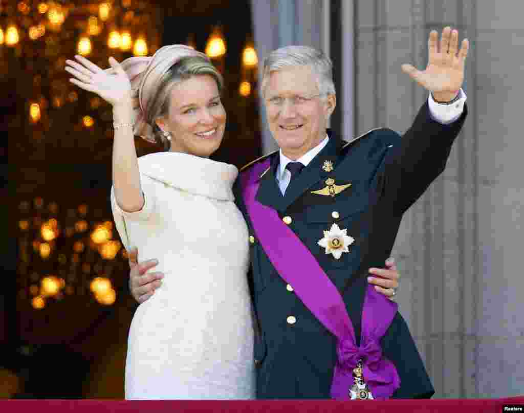 Los reyes de Belgica Mathilde y Aberto saludan desde el balcón del Palacio Real en Bruselas durante las celebraciones del día nacional y la investidura de Felipe.