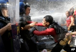 A protester pushes a police as they are dispersed while trying to get near the U.S. Embassy in Manila, Philippines to protest against the visit of U.S. President Donald Trump on Sunday Nov. 12, 2017.