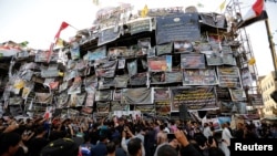 Iraqi people mourn at a makeshift shrine for victims of the Karrada suicide bomb attack at the site where the incident took place in Baghdad, Iraq, July 10, 2016. 