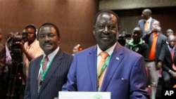 Le candidat Raila Odinga (à dr.), montre son certificat d'inscription à Nairobi, Kenya, le 30 jan. 2013.