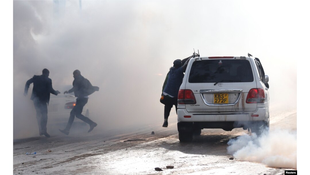 Politicians run after riot police fired tear gas to disperse the convoy of Kenyan opposition leader Raila Odinga of the National Super Alliance (NASA) coalition upon Odinga's return to Nairobi, Nov. 17, 2017.