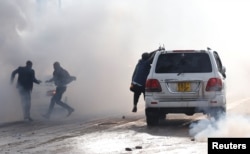 Politicians run after riot police fired tear gas to disperse the convoy of Kenyan opposition leader Raila Odinga of the National Super Alliance (NASA) coalition upon Odinga's return to Nairobi, Nov. 17, 2017.