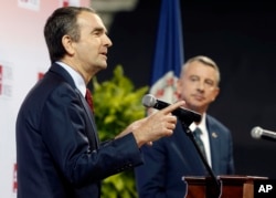 FILE - Democratic candidate for Virginia governor Ralph Northam, left, gestures during a debate with Republican challenger Ed Gillespie, at the University of Virginia-Wise, in Wise, Virginia, Oct. 9, 2017. Defeated by Northam, Gillespie was being closely watched by Republican strategists gauging how him distancing himself from President Donald Trump would fair with voters.