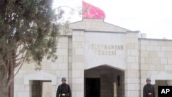 ທະຫານເທີກີຢືນຍາມຢູ່ທາງເຂົ້າຫາສຸສານຂອງກະສັດ Suleyman ພໍ່ຕູ້ຂອງມື້ລາງ ຜູ້ກໍ່ຕັ້ງ ອານາຈັກ Ottoman ໃນບ້ານ Karakozak, ຊີເຣຍ, ວັນທີ 7 ເມສາ 2011. 