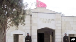 FILE - Turkish soldiers stand guard at the entrance to the memorial site of Suleyman Shah, grandfather of Osman I, founder of the Ottoman Empire, in Karakozak village, northeast of Aleppo, Syria, April 2011. 