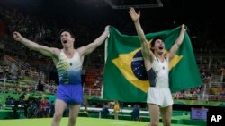 Vận động viên Brazil Arthur Mariano (phải) và đồng đội Diego Hypolito ăn mừng chiến thắng với huy chương đồng và bạc bộ môn thể dục dụng cụ nam.