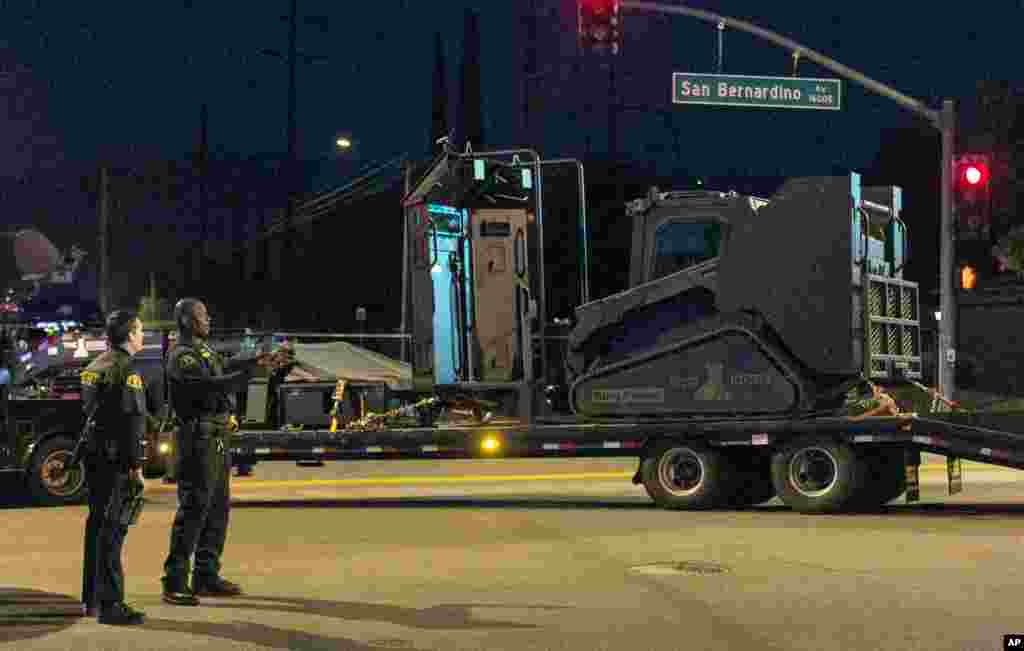 Cảnh sát đứng cạnh một chiếc xe bọc thép sau khi tìm kiếm gần một khu vực ở San Bernardino sau vụ nổ súng, ngày 2/12/2015.