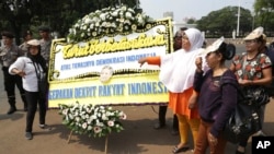 Protesters hold a placard during a rally, opposing a regional election bill in front of palace in Jakarta, Sept 29, 2014.