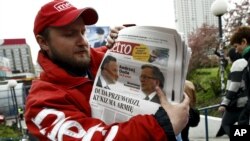 Seorang penjual koran "Metro" di Warsawa, Polandia memperlihatkan edisi terbaru yang menampilkan gambar Presiden Polandia Bronislaw Komorowski dan penantangnya Andrzej Duda di halaman depan, sehari setelah diselenggarakannya Pilpres putaran pertama (11/5).