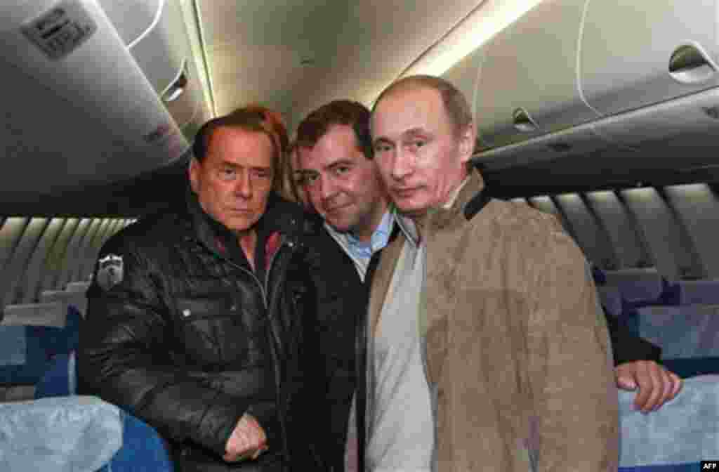 Russian President Dmitry Medvedev, center, Prime Minister Vladimir Putin, right, and Italian Prime Minister Silvio Berlusconi pose while examining a new Russian passenger plane, Sukhoi Superjet 100, at the airport in the Black Sea resort of Sochi, sout