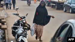 FILE - A Muslim woman walks in the Brituetterie district of Yaounde, Cameroon, July 16, 2015.