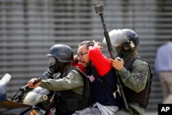 A protester taking part in an anti-government march to the Supreme Court is detained and driven away by members of the Bolivarian National Guard in Caracas, Venezuela, July 6, 2017.