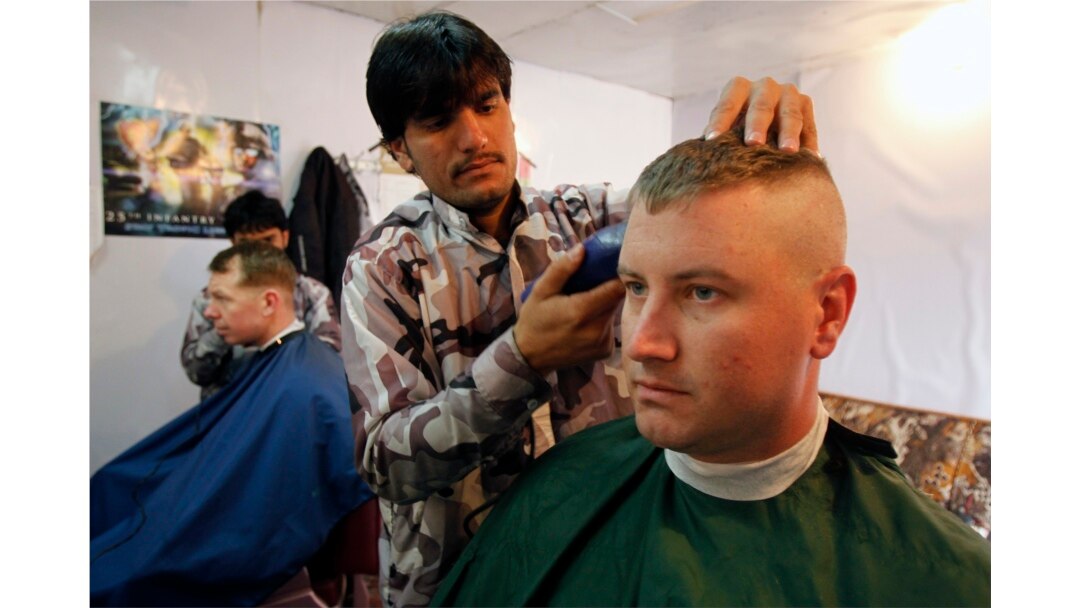 Warga Afghanistan memotong rambut tentara AS dari Batalyon ke-2, Divisi Infanteri ke-35, Satuan Tugas Kaktus di sebuah pangkas rambut di Provinsi Kunar, Afghanistan timur 13 Maret 2012. (Foto: REUTERS/Erik De Castro)