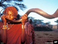 A Maasai man blows an antelope horn