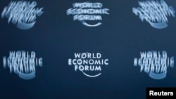 FILE - A logo, taken with long exposure, is shown at the World Economic Forum headquarters in Cologny, near Geneva.