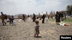 A girl carries food aid she received from the local charity, Mona Relief, on the outskirts of Sana'a, Yemen, May 5, 2019.