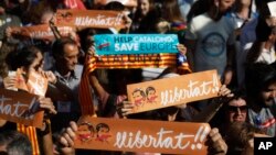 Protesters holds banners that read in Catalan '' freedom'' showing the portraits of the inprisoned Jordi Sanchez and Jordi Cuixart, leaders of the Catalan grassroots organizations Catalan National Assembly and Omnium Cultural, during a rally outside the C