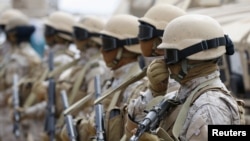 FILE - Saudi troops stand at attention at their base in Yemen's southern port city of Aden, Sept. 28, 2015.