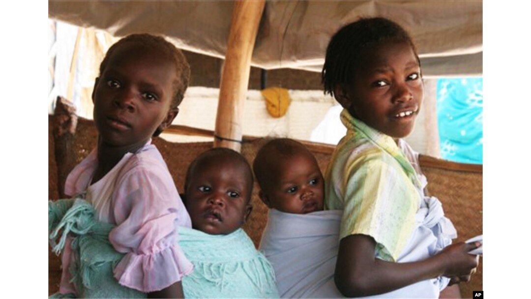 Two refugee girls carry their mothers child at the south Darfur refugee camp of Kalma April 10, 2007.The Darfur conflict has become the world's worst humanitarian crisis, and rape is its regular byproduct, U.N. and other human rights activists say. Sudan'