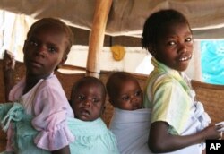 Two refugee girls carry their mothers child at the south Darfur refugee camp of Kalma April 10, 2007.The Darfur conflict has become the world's worst humanitarian crisis, and rape is its regular byproduct, U.N. and other human rights activists say. Sudan'