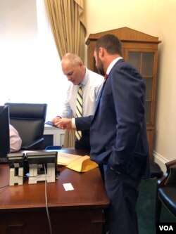 Rep. Pete Stauber (R - Minn) is coached by veteran congressman on usefulness of Capitol ID badges, car license plates. (Photo: Carolyn Presutti / VOA)