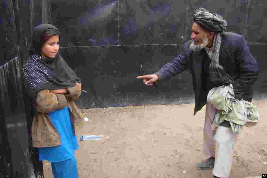 Abdul Ghafar talks to her daughter known as Spozhmai in protective custody in Lashkargah, capital of Helmand province, south of Afghanistan. The father of the girl, who police say was part of a botched suicide bomb attack, said he's afraid the Taliban will kill him and his daughter if they return to their village.