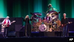 John McVie, from left, and Stevie Nicks and Lindsey Buckingham of Fleetwood Mac perform at the Isle of Wight Festival, in Newport, Isle of Wight, England, June 14, 2015.
