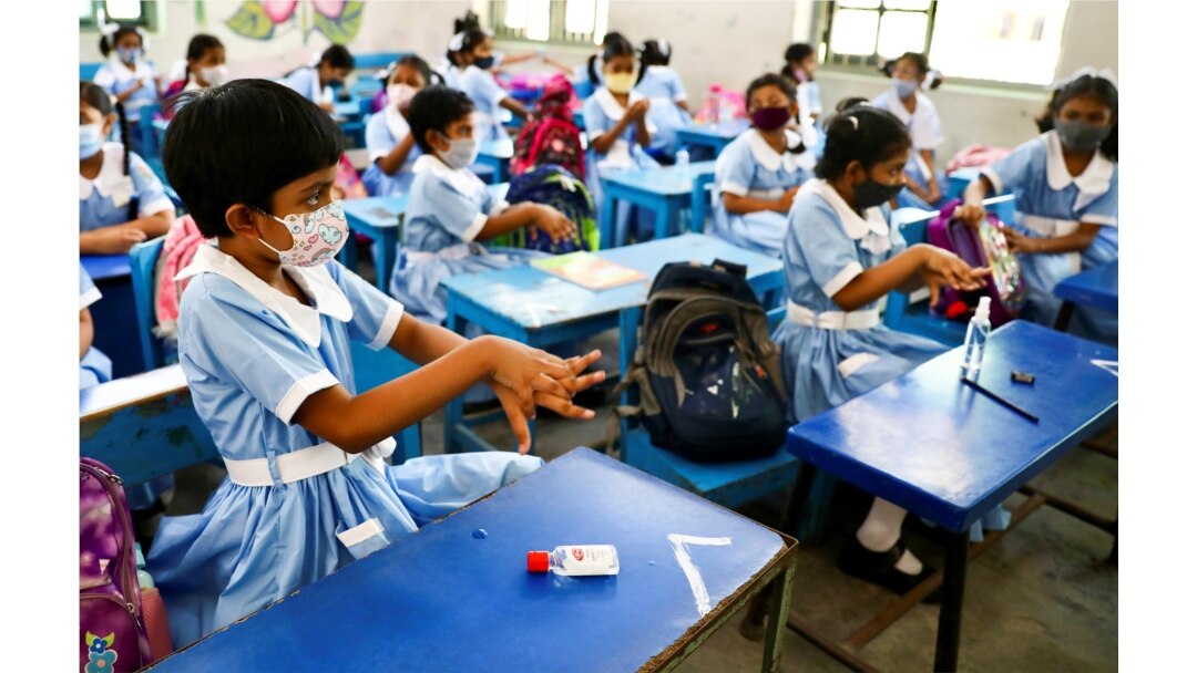 Students apply hand sanitiser in a class at the Viqarunnisa Noon School & College after the government has withdrawn restrictions on educational institutions following a decrease in the number of cases of COVID-19 in Dhaka, Bangladesh, Sept. 12, 2021.