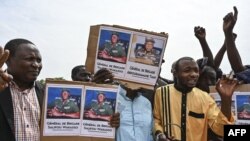 A supporter of Niger's National Council for the Safeguard of the Homeland (CNSP) holds up a placeard with a photo of General Abdourahamane Tiani on in Niamey on August 6, 2023.