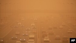 Vehículos en una autopista de Beijing a la hora pico de tráfico, el lunes 15 de marzo de 2021, en medio de una tormenta de arena.