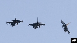 Three Dutch F-16 aircraft prepare for landing at the Decimomannu airbase, in Sardinia, Italy, Thursday, March 24, 2011.