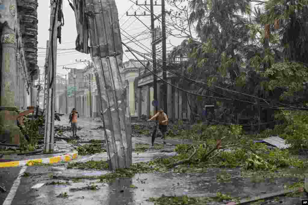 Líneas eléctricas caídas, metal y ramas de árboles ensucian una calle después de que el huracán Ian azotara Pinar del Río, Cuba, el martes 27 de septiembre de 2022. Ian tocó tierra a las 4:30 a.m. EDT del martes en la provincia cubana de Pinar del Río, donde las autoridades instalaron albergues, enviaron personal de emergencia y tomaron medidas para proteger los cultivos de tabaco. (Foto AP/Ramón Espinosa)