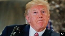 President Donald Trump pauses as he answers questions in the lobby of Trump Tower in New York, Aug. 15, 2017. 