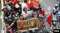 Kelompok Kaos Merah melakukan unjuk rasa dengan membawa gambar Raja dan Ratu Thailand di Bangkok, 28 April 2010.