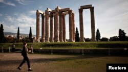 A tourist makes her way at the archaeological site of the Temple of the Olympian Zeus in Athens, Greece.