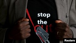 FILE- A man shows the logo of a T-shirt that reads "Stop the Cut" referring to Female Genital Mutilation (FGM) in Imbirikani, Kenya, April 21, 2016. 