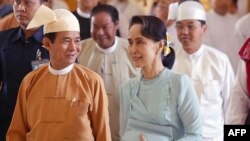 Myanmar's State Counselor Aung San Suu Kyi (R) accompanies new President Win Myint (L) to take his oath of office at parliament in Naypyidaw, March 30, 2018.