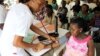 A nurse inspects a pregnant woman outside a ward at a maternity hospital in Obio district in Nigeria's oil city of Port Harcourt, March 24, 2011.