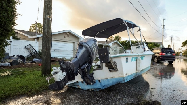 Sebuah perahu terhempas di jalan akibat banjir yang dipicu Badai Helene di Hudson, Florida, 27 September 2024.