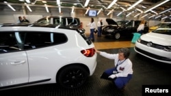 Employees work on an assembly line at the Volkswagen factory in Palmela, Portugal, Dec. 9, 2016.