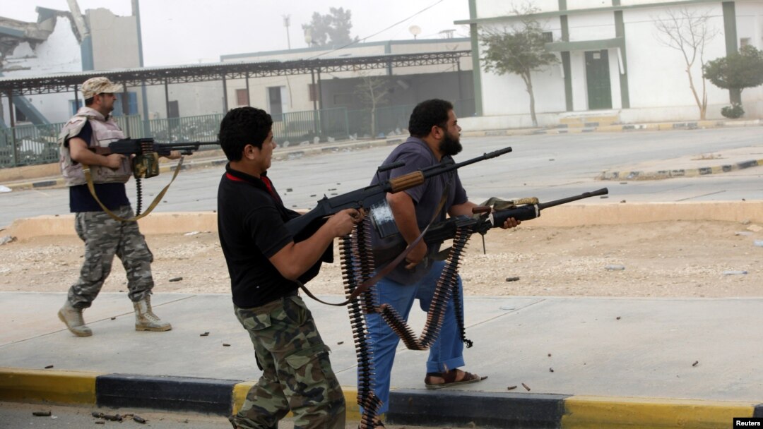 Para anggota milisi Libya menembaki sebuah bangunan (foto: dok). Kawanan bersenjata menewaskan seorang warga AS di Benghazi Kamis, 5/12. 