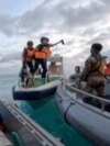 FILE - In this image provided by Armed Forces of the Philippines, a Chinese Coast Guard holds an axe as they approach Philippine troops on a resupply mission in the Second Thomas Shoal at the disputed South China Sea on June 17, 2024. 