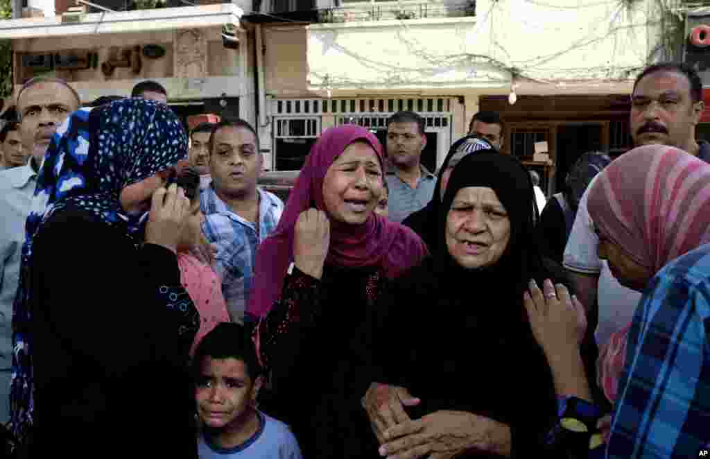 Egyptian women weep near the scene after a roadside bomb went off on a busy street in downtown near the foreign ministry in Cairo.